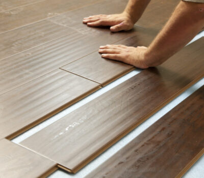 Man Installing New Laminate Wood Flooring Abstract.